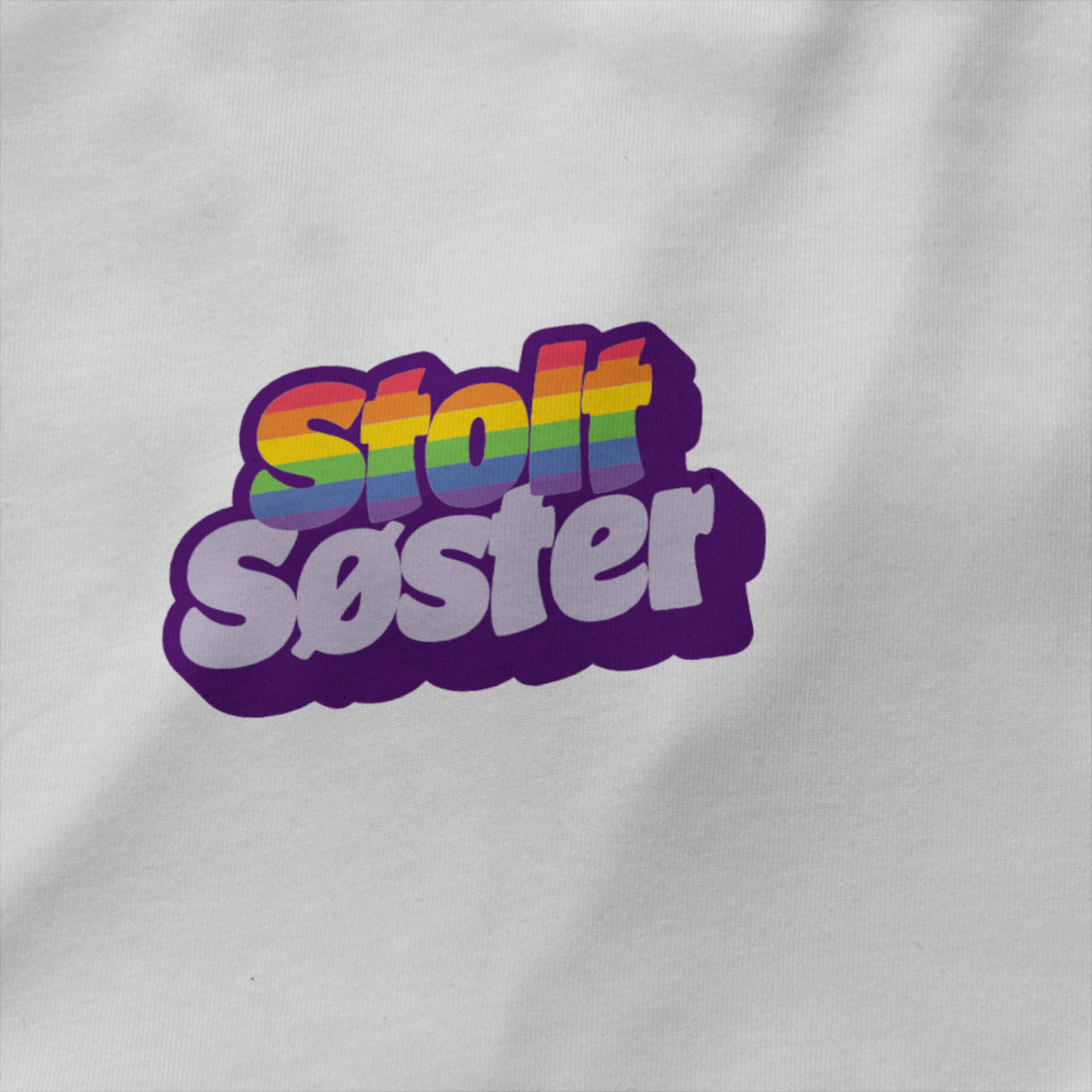 Hvit unisex T‑skjorte med teksten ‘Stolt Søster’ i regnbuefarger – enkel rund hals, single jersey og inkluderende Pride-design nærbilde