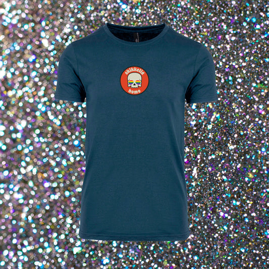 Hvit unisex T‑skjorte med trykket ‘Skikkelig Homo’ i sirkel – hodeskalle med regnbue-briller i midten, rund hals og enkel stil.