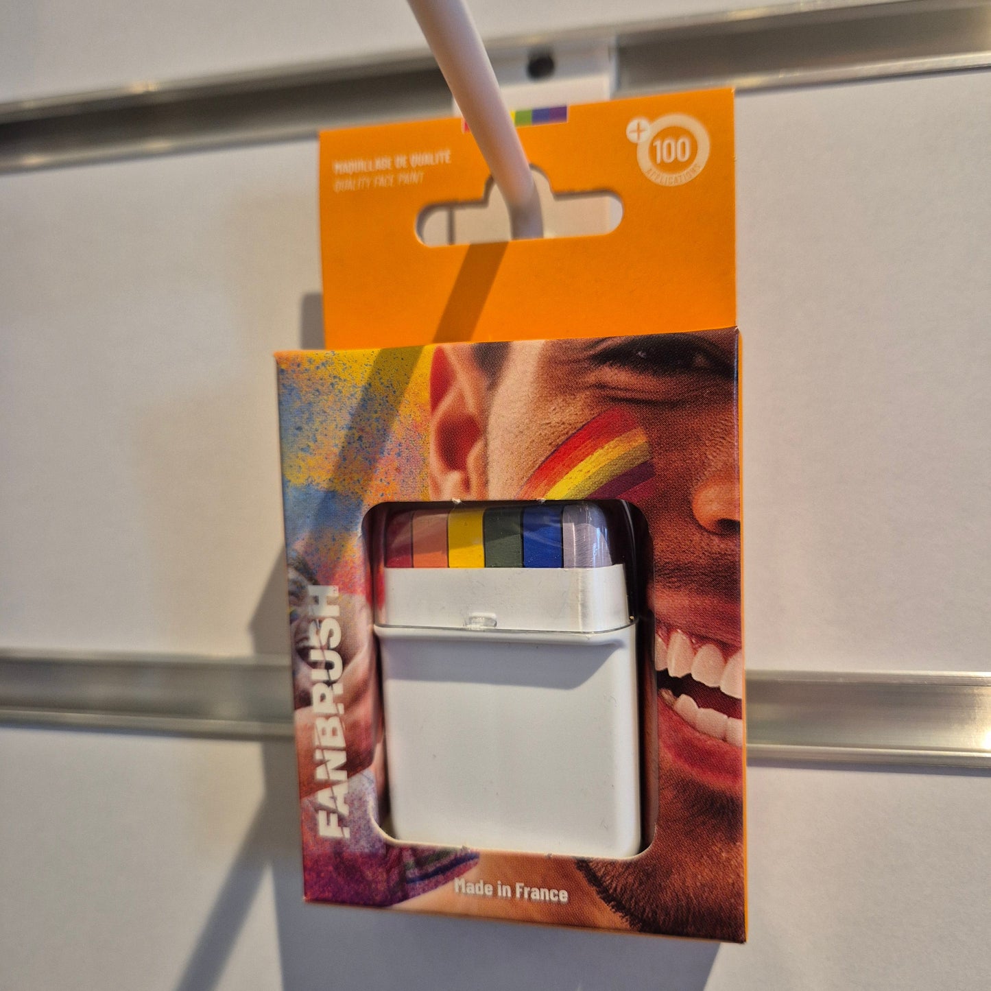 Fanbrush med regnbuens farger – rød, oransje, gul, grønn, blå og lilla – kremet ansiktsmaling for fargerike uttrykk.