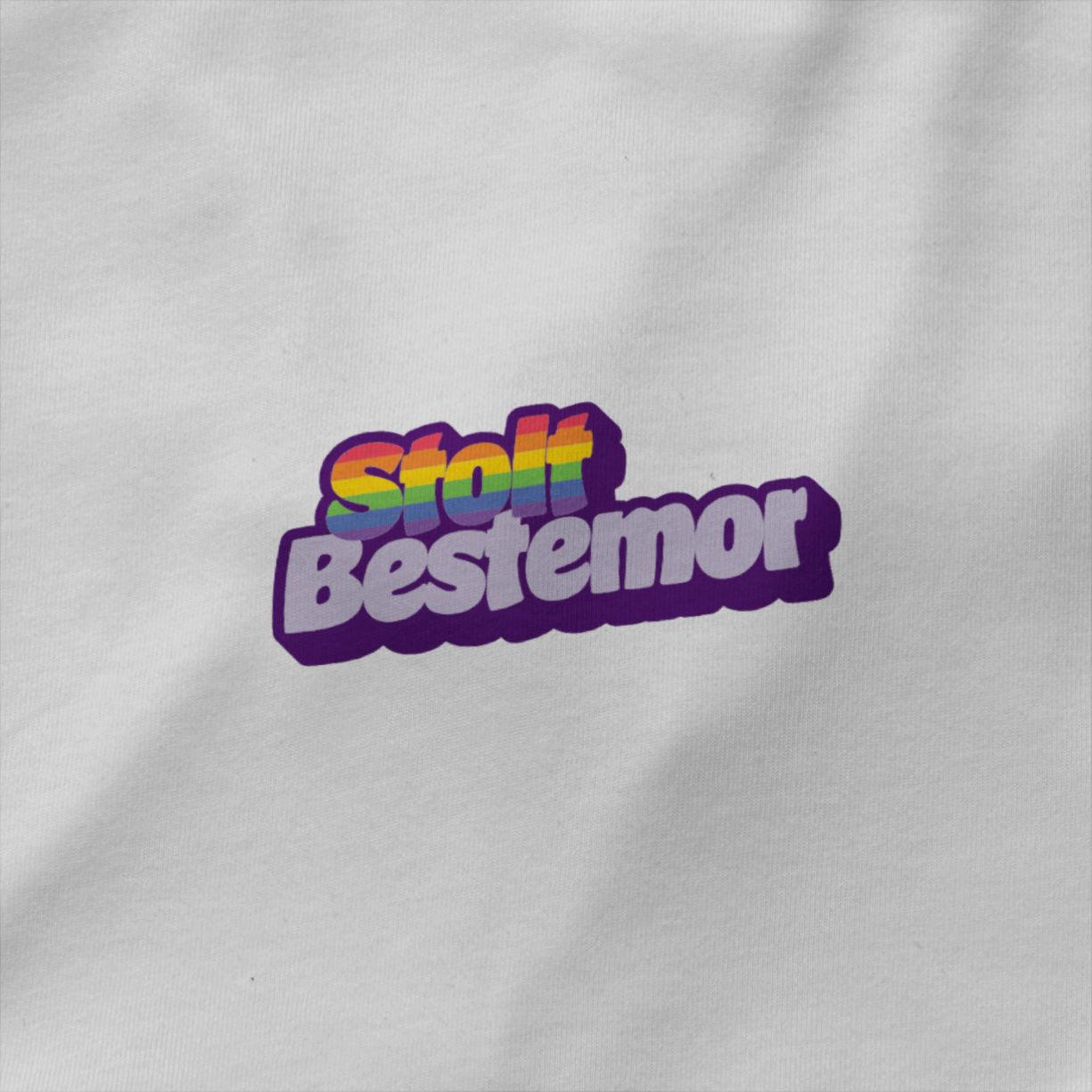 Hvit unisex T‑skjorte med teksten ‘Stolt bestemor’ i regnbuefarger – enkel rund hals, single jersey og inkluderende Pride-design.