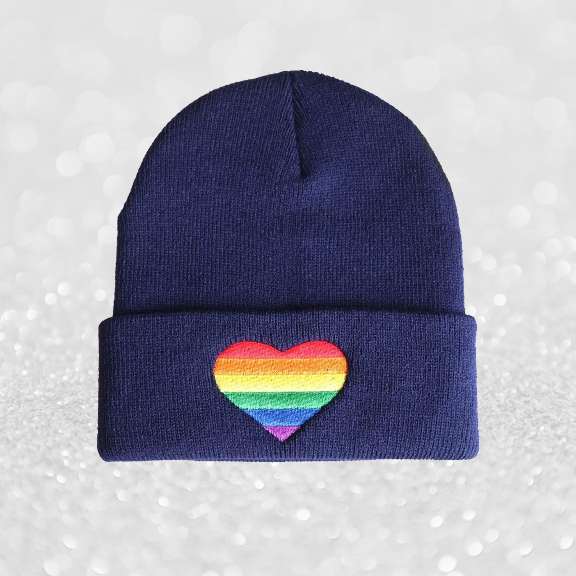 lue med brodert regnbuefarget hjerte, varm og stilfull måte å vise Pride-støtte på.